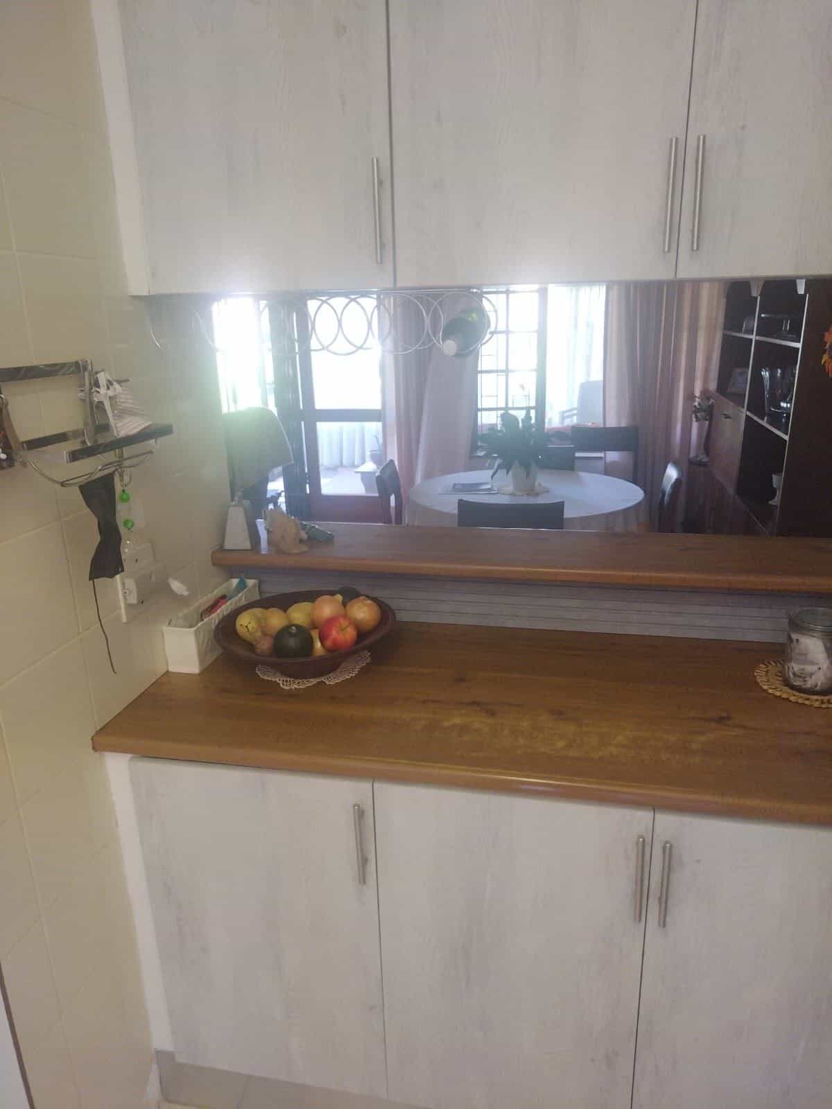 Whitewash wall and base cupboards with a timber breakfast counter