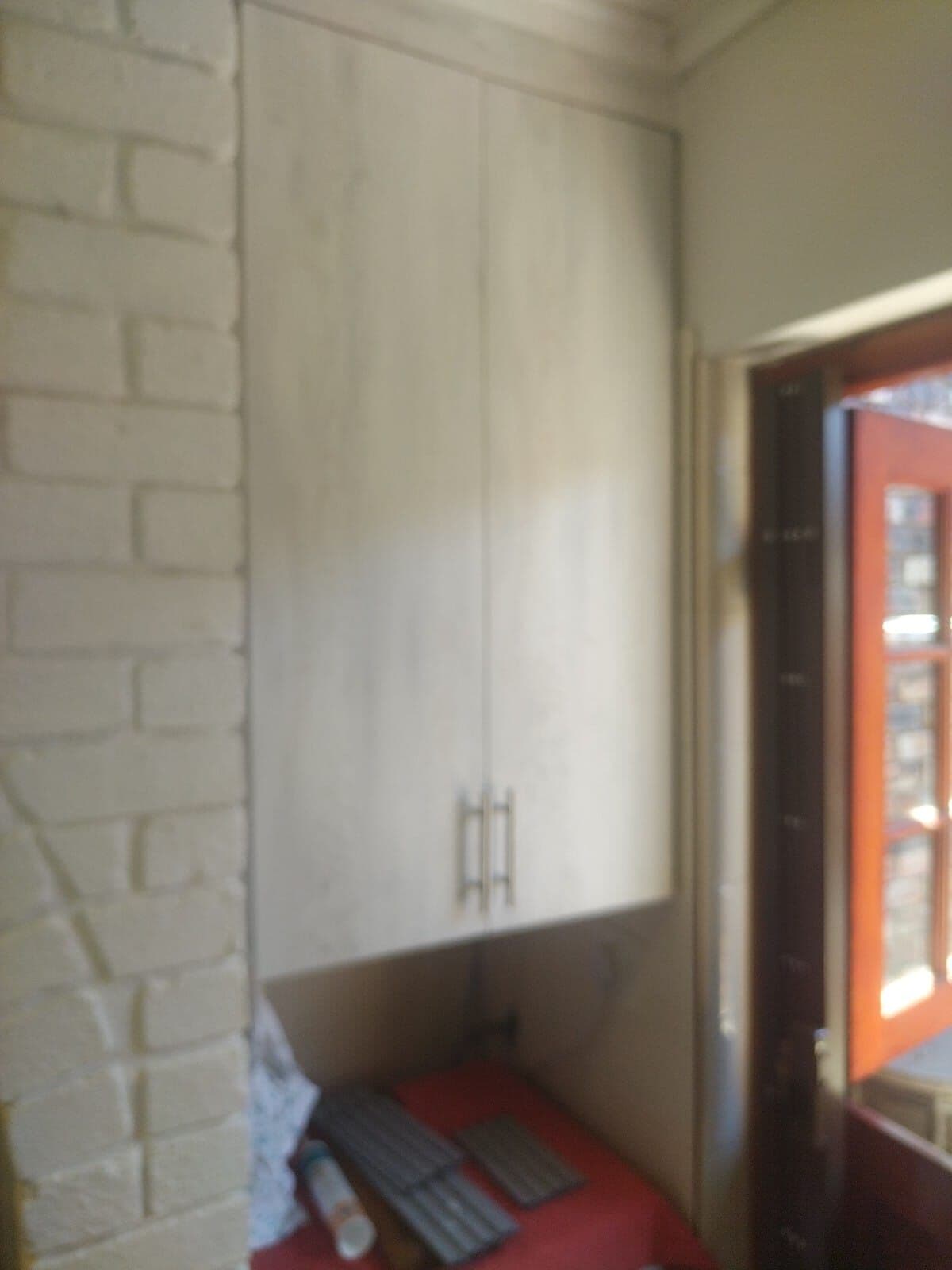 Tall built-in storage cupboard fitted beside a doorway by Elite Home Finishes