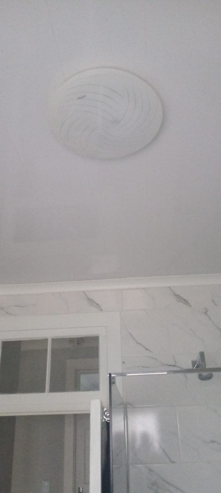 Bathroom ceiling and cornice finished above marble-look tiles