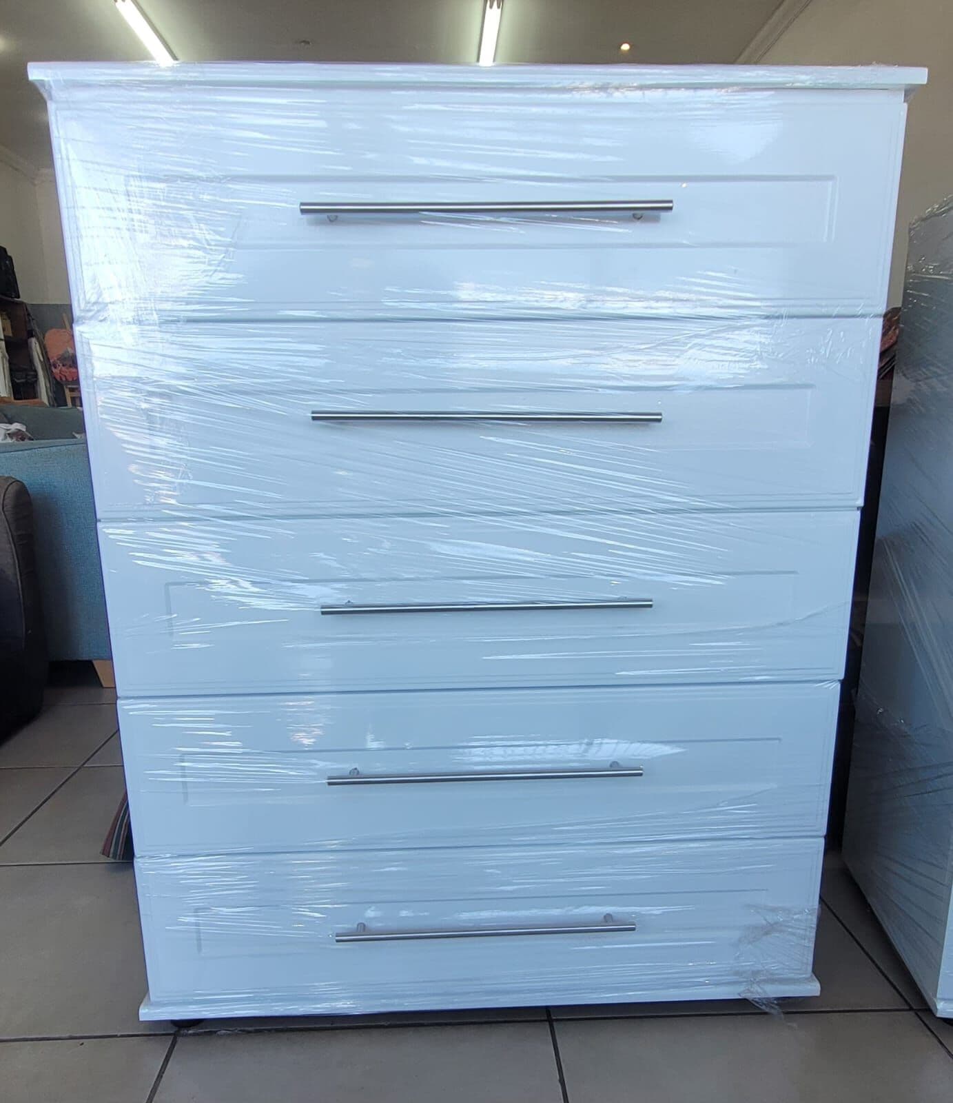 White five-drawer chest wrapped and ready for delivery