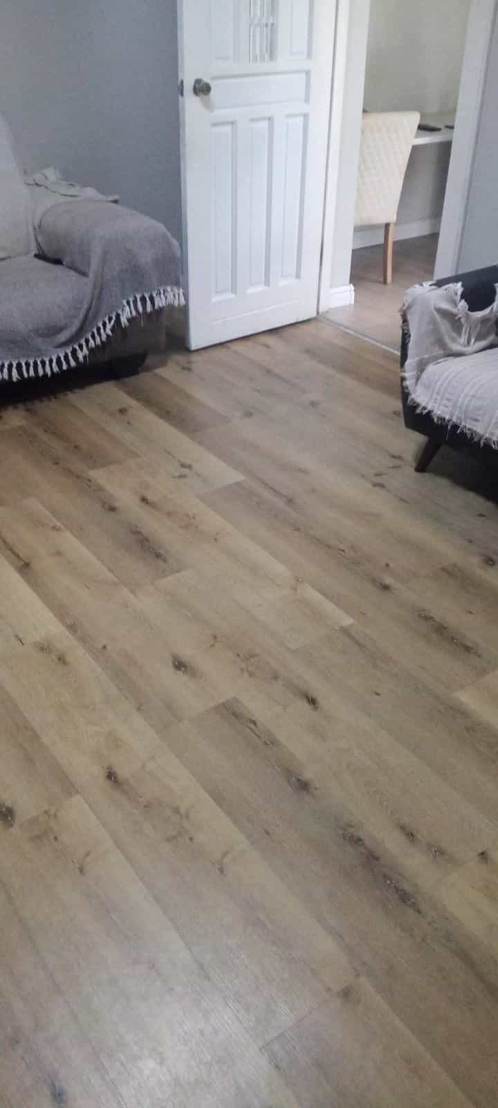 Oak-look plank flooring installed in a lounge by Elite Home Finishes
