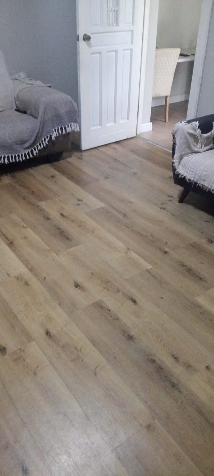 Oak-look plank flooring installed in a lounge by Elite Home Finishes