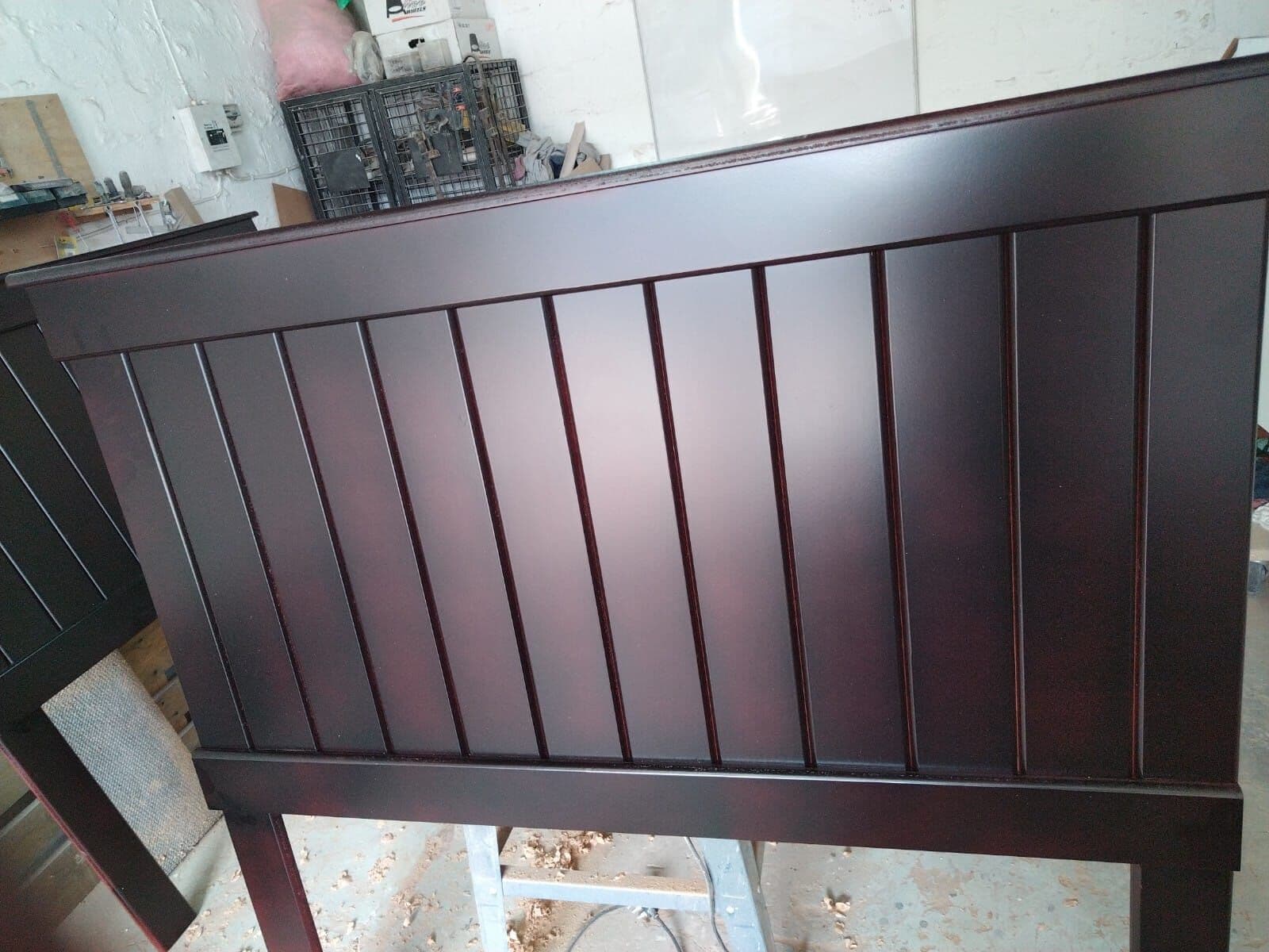 Dark stained timber headboard with vertical panels