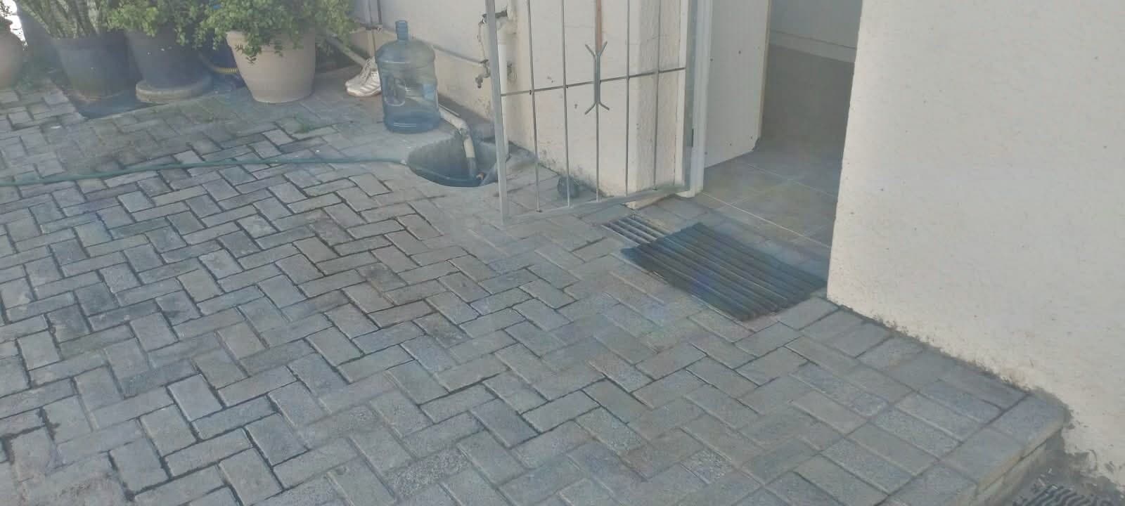 Interlocking brick paving laid in a herringbone pattern at a courtyard entrance